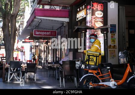 Sydney, Australie. 29 juillet 2020. Un liveur attend devant un restaurant dans le quartier chinois de Sydney, en Australie, le 29 juillet 2020. Aujourd'hui, avec des cas record de COVID-19 dans la ville de Melbourne et Sydney, potentiellement au bord d'une deuxième vague, les restaurants et les bars se préparent à être frappés par un retour au confinement alors qu'ils peinent à survivre. POUR ALLER AVEC 'Feature: Les restaurants emblématiques de Chinatown de Sydney s'adaptent à la vie sous COVID-19' crédit: Bai Xuefei/Xinhua/Alay Live News Banque D'Images