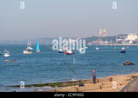 Pêche à la plage dans l'estuaire de la Tamise au large de Shoeburyness, Southend on Sea, Essex, Royaume-Uni, avec canoë. Bateaux et yachts. Horizon Southend Banque D'Images