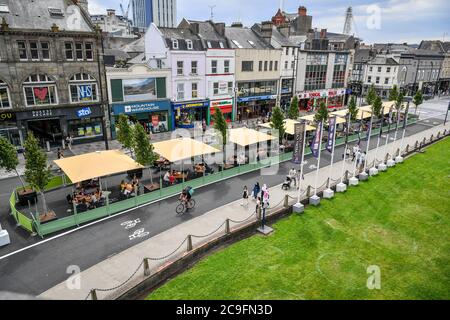 Des salles à manger en plein air sont érigées dans une nouvelle zone piétonne sur Castle Street, dans le centre-ville de Cardiff, comme l'a annoncé le premier ministre du pays de Galles, Mark Drakeford, qui a annoncé lundi jusqu'à 30 personnes peuvent se retrouver à l'extérieur tout en maintenant une distanciation sociale dans le dernier assouplissement des mesures de coronavirus au pays de Galles. Banque D'Images