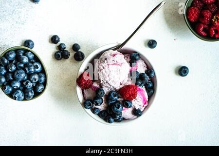 Crème glacée d'été aux fruits, avec baies de myrtille fraîches et biologiques servies dans un bol sur fond de pierre avec espace de copie Banque D'Images