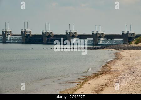 Détail du système de protection longue durée contre les inondations. Plage de sable et eau bleue, nuages blancs dans le ciel gris. Zeeland, pays-Bas. Banque D'Images