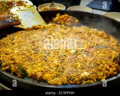 Riz frit après le fromage Dak-galbi, côte de poulet épicée sautée, légumes, nouilles et fromage sur le gril - Corée du Sud. Cuisine populaire coréenne. Banque D'Images