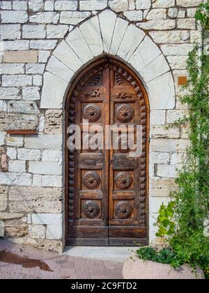 Ancienne porte en bois sculpté vintage. Ancien mur en pierre avec porte d'époque. Banque D'Images