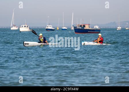 Deux mâles blancs plus âgés qui ravirent des canoës dans l'estuaire de la Tamise, au large de Thorpe Bay, Southend on Sea, Essex, Royaume-Uni. Canoë-kayak sur la Tamise Banque D'Images