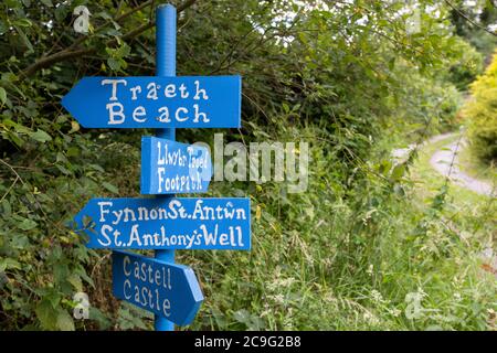 Des panneaux bilingues peints attrayants (gallois et anglais) dans l'ouest du pays de Galles pointent vers la plage, le château et d'autres attractions Banque D'Images