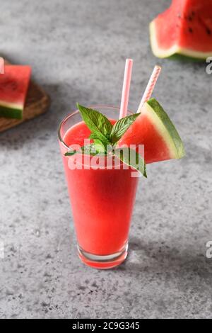 Un verre de cocktail de pastèque décorez la menthe sur fond gris. Banque D'Images