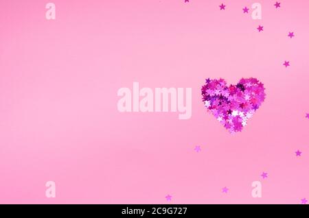 Coeur rose étincelant en petites étoiles sur fond rose clair. Carte de Saint-Valentin. Vue de dessus, plan d'appartement. Copier l'espace Banque D'Images