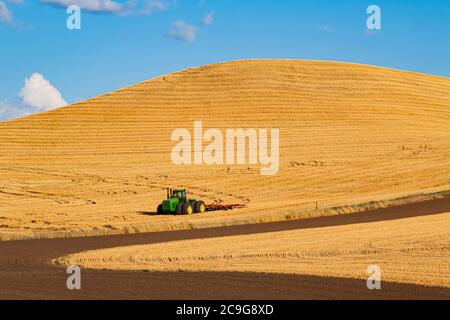 Gros tracteur stationné dans un champ de céréales récemment récolté dans la région de Palouse, dans l'est de l'État de Washington, États-Unis Banque D'Images