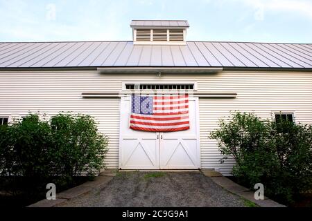 An American flag hangs on a barn near Woodstock, Vermont. Banque D'Images