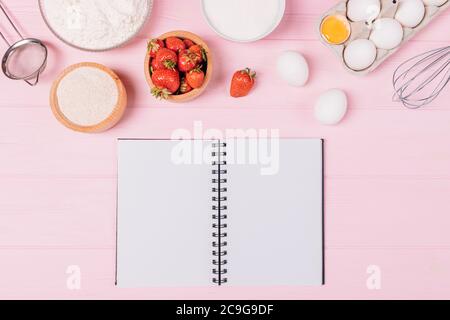 Carnet vierge à côté des ingrédients et des ustensiles pour cuisiner tarte aux fraises maison, plat. Banque D'Images