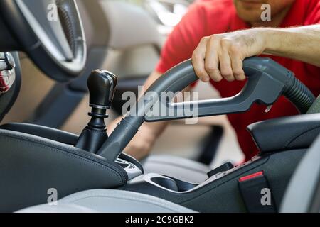 homme nettoyant l'intérieur de la voiture avec un aspirateur Banque D'Images