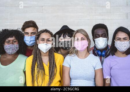 Les jeunes du groupe portent un masque facial pour prévenir l'éclosion de virus corona - amis du millénaire avec un portrait différent d'âge et de culture Banque D'Images