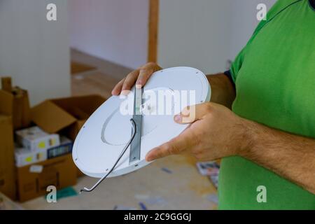 Gros plan une main change une LED lumineuse dans une préparation élégante pour l'installation d'éclairage intérieur de plafonnier Banque D'Images