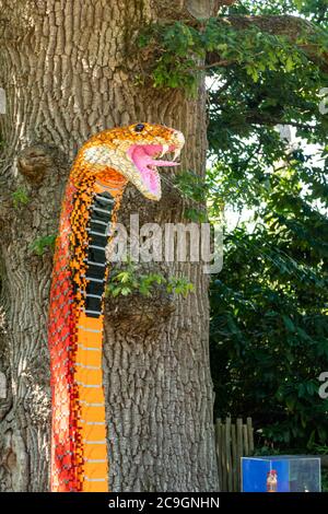 Des modèles d'animaux en briques lego de grande taille au zoo de Marwell, Royaume-Uni, un sentier d'activités pour enfants. Un modèle de cobra à cracher rouge de travail. Banque D'Images