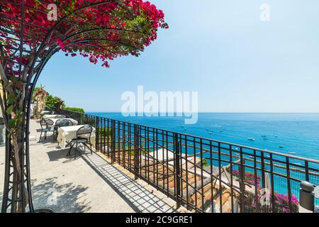 Tables et chaises bougainvilliers fleuris sur le front de mer de Positano. Côte amalfitaine, Italie Banque D'Images