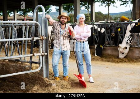 Portrait d'une famille de fermes confiante et prospère engagée dans l'élevage de vaches posant dans le cheptel Banque D'Images