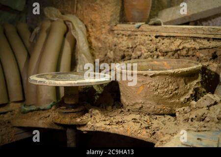 Disque rotatif pour la poterie dans un atelier de poterie. Ensemble d'outils de sculpture d'art sale et d'artisanat sur une table en bois dans un atelier de poterie Banque D'Images