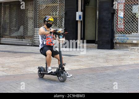 Jérusalem, Israël - 30 juillet 2020 : un scooter motorisé portant un masque de protection COVID sur une rue de Jérusalem, Israël. Banque D'Images