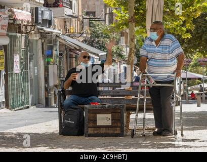 Jérusalem, Israël - 30 juillet 2020 : deux hommes âgés ayant une conversation portant un masque de protection COVID sur une rue de Jérusalem, Israël. Banque D'Images