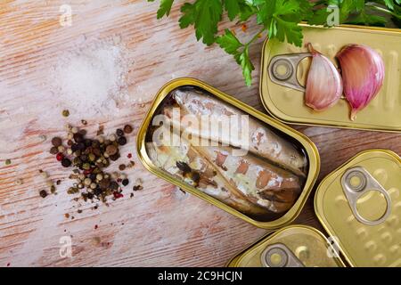 Fruits de mer conservés, boîte ouverte de poisson en conserve au maquereau avec condiments sur une table en bois Banque D'Images