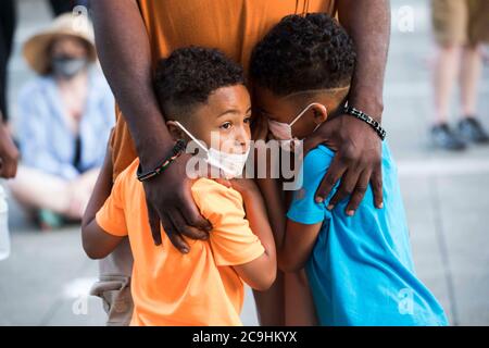 29 juillet 2020, Gresham, OREGON, Etats-Unis: GERMAINE FLENTROY, repose ses mains sur ses deux fils GEREME (cq) (à gauche, en t-shirt orange), 4 ans, Et ALLEMAND (cq), droite, 6 ans, tout en écoutant le nouveau conseiller municipal de Gresham VINCE JONES-DIXON s'adresser à la foule lors du rassemblement familial paisible de Black Lives Matter à l'hôtel de ville de Gresham, en Oregon, le mercredi 29 juillet 2020. JONES-DIXON est le premier Noir à servir de conseiller municipal et a été nommé le 21 juillet. Le conseil municipal de Gresham a voté lundi 20 juillet pour lever le drapeau de la question de la vie noire à l'hôtel de ville et a été attaqué par le Conseil de Multnomah Banque D'Images