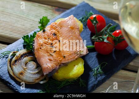 L'ardoise avec de tendres filets de truite, les pommes de terre, tomates cerises et les verts Banque D'Images