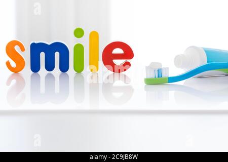 Le mot « smile » en lettres multicolores avec une brosse à dents, sur fond blanc. Banque D'Images