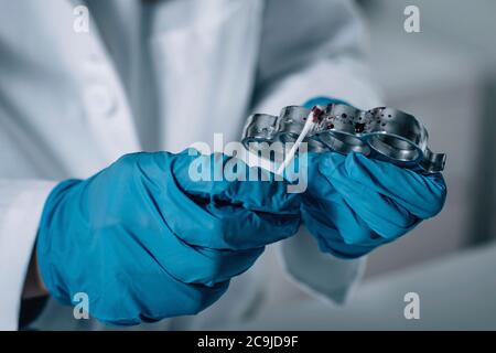 Médecine légale en laboratoire. Scientifique médico-légal examinant un porte-fusée pour preuve. Banque D'Images