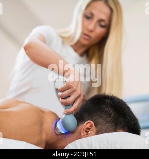Thérapeute traitant la douleur du cou avec l'échographie. Banque D'Images