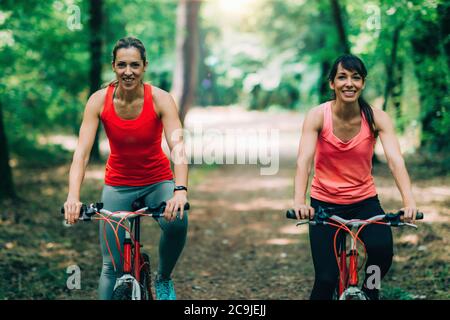 Des amies qui se rassemblent en vélo dans le parc. Banque D'Images