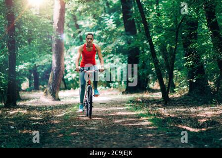 Femme à vélo dans le parc.