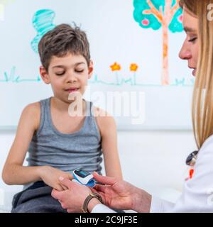 Pédiatre mesurant l'oxygène dans le sang et le rythme cardiaque avec l'oxymètre de pouls. Banque D'Images