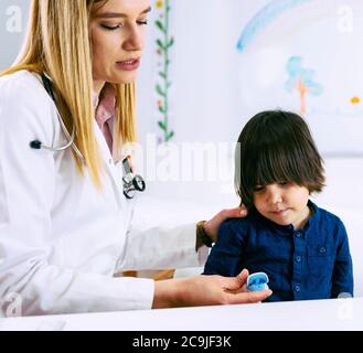 Pédiatre mesurant l'oxygène dans le sang et le rythme cardiaque avec l'oxymètre de pouls. Banque D'Images