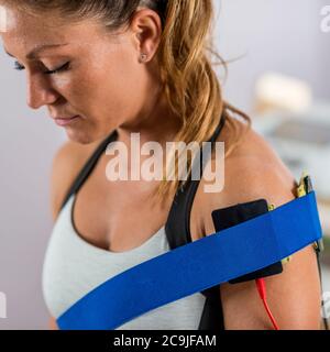 Stimulation musculaire électrique en physiothérapie. Electrodes placées au niveau de l'épaule du patient. Banque D'Images