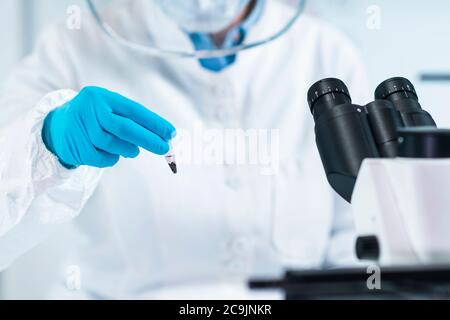 Analyse de l'ADN antique. Scientifique femelle tenant un micro tube avec échantillon dans un laboratoire d'ADN ancien. Banque D'Images