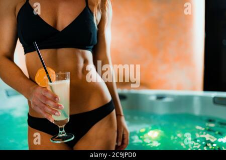 Femme appréciant un bain à remous dans un spa. Boire de la limonade et se détendre. Banque D'Images