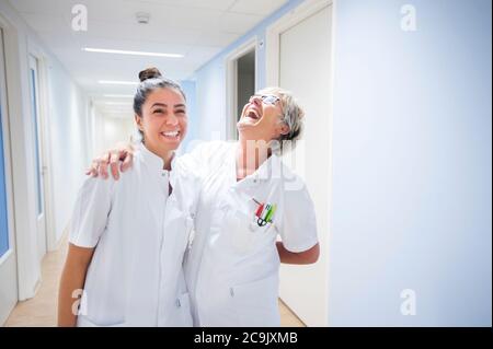 Les infirmières rient dans le couloir. Banque D'Images