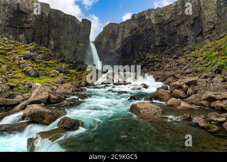 Une cascade mystérieuse cachée dans la nature dans la campagne islandaise, des montagnes rocheuses avec de la mousse et des ruisseaux turquoise. Cela a un flux puissant. Banque D'Images