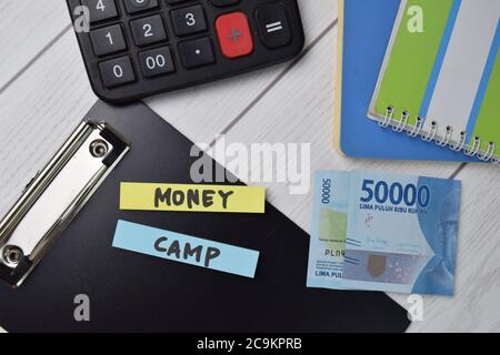 Le texte Money Camp est écrit sur des notes adhésives isolées sur le bureau. Banque D'Images