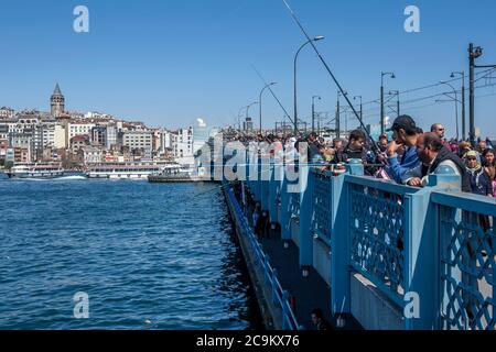 Des centaines de pêcheurs se tiennent sur le pont de Galata à Istanbul, en Turquie, attendant que le poisson mord. Ils ont jeté leurs tiges dans la Corne d'Or. Banque D'Images