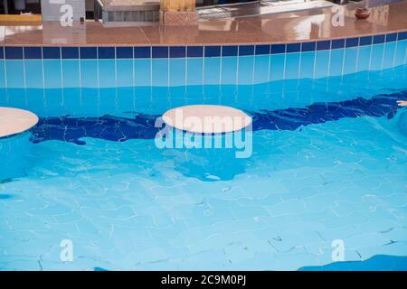 comptoir de bar dans la piscine avec eau claire et chaises Banque D'Images