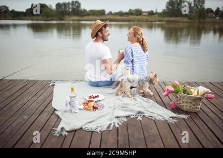 Bonne épouse appréciant un pique-nique sur le quai du lac Banque D'Images