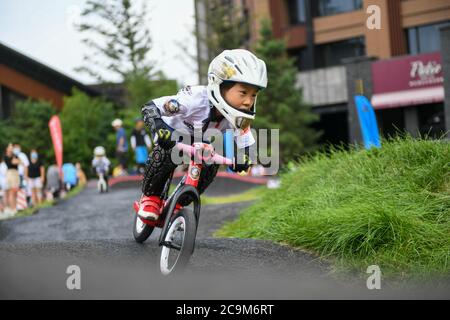 (200801) -- BEIJING, le 1er août 2020 (Xinhua) -- UN garçon fait du vélo dans une station balnéaire de Jilin City, dans la province de Jilin, au nord-est de la Chine, le 19 juillet 2020. (Xinhua/Yan Linyun) Banque D'Images