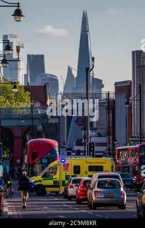 Londres, Royaume-Uni. 1er août 2020. Une ambulance de garde traverse la rue Brixton High Street à la suite de la levée de l'écluse du coronavirus (COVID-19). Avec la City de Londres qui se profile à l'horizon, en contraste avec le bruit de fond. Crédit : Guy Bell/Alay Live News Banque D'Images