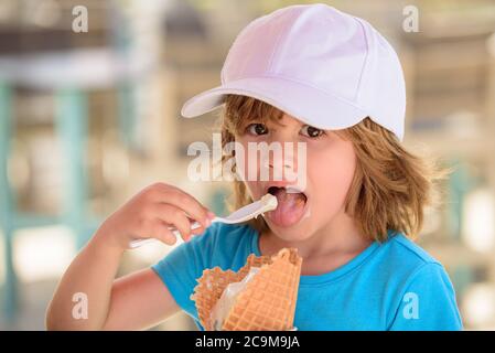 Enfant mangeant de la glace. Un enfant mignon qui lèche une grande glace dans un cône de gaufres. Banque D'Images