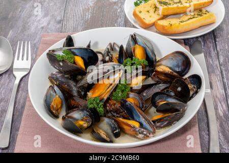 Moules cuites à la vapeur mariniere avec pain à l'ail Banque D'Images