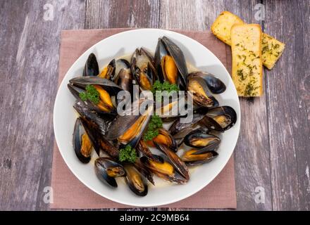 Moules cuites à la vapeur mariniere avec pain à l'ail Banque D'Images