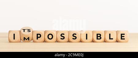 Changer le mot impossible dans son possible. Dés en bois avec texte sur la table. Copier l'espace Banque D'Images
