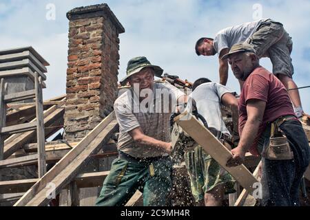 Zrenjanin, Serbie, 22 juillet 2020. Un groupe de maîtres travaille sur le toit d'une maison privée pour remplacer un vieux carrelage. Ils ont une belle journée et stable Banque D'Images