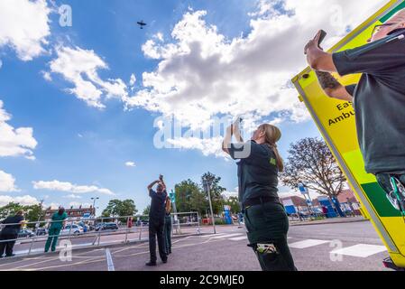 Southend University Hospital, Southend on Sea, Essex, Royaume-Uni. 1er août 2020. L'Aircraft Restoration Company, basée à l'aérodrome de Duxford à Cambridgeshire, a peint « THANK U NHS » sur le dessous de leur Spitfire bleu de la Seconde Guerre mondiale en l'honneur du travail effectué pendant la pandémie du coronavirus COVID-19 par le National Health Service. Aujourd'hui, le Spitfire est passé de Duxford au-dessus de l'hôpital de Southend, avant de se diriger vers les hôpitaux de Kent. Certains membres du personnel de santé sont venus observer. Un certain nombre de membres du personnel de Southend ont été perdus à cause du virus. Ambulanciers photographiant et filant avec des téléphones Banque D'Images